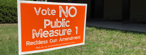 An orange sign out in the yard that says "Vote NO Public Measure 1, Reckless Gun Amendment"
